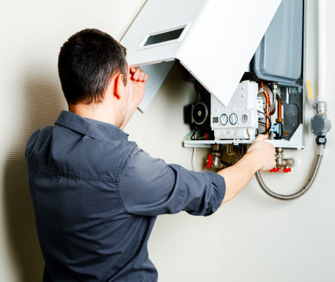 Técnico de fontanería revisando caldera de gas en Valencia